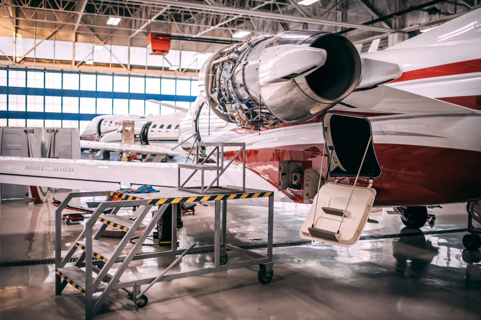 Jet engine undergoing maintenance inside an aircraft hangar.